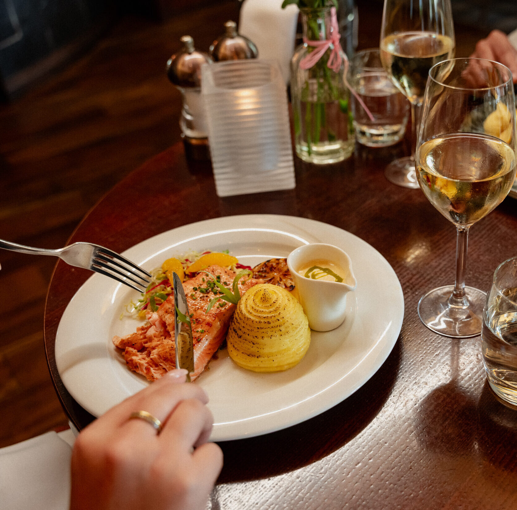 Over the shoulder image of guest about to enjoy a Salmon and potato dish