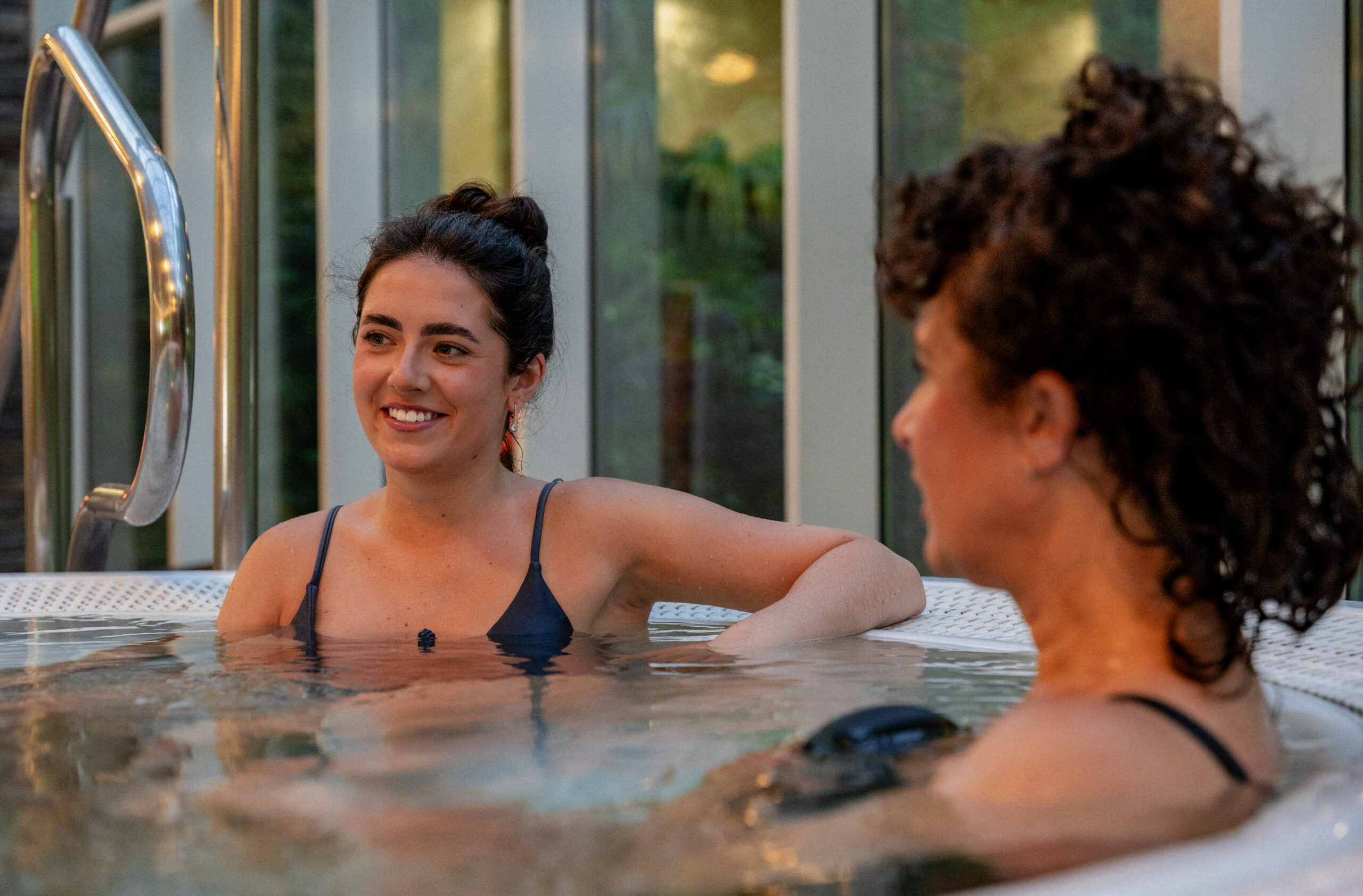 Ladies smiling with one another in the hot tub