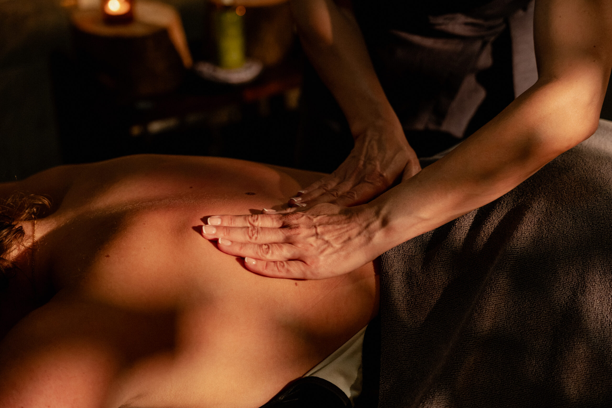 Hands placed on guests back during spa treatment