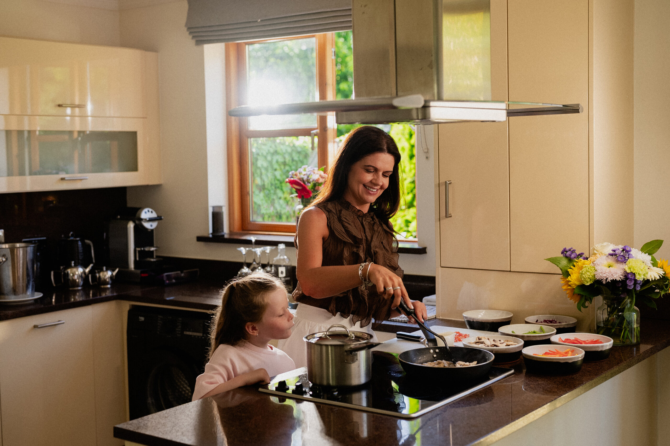 Mother cooking dinner in kitchen of self catering lodge as child watches