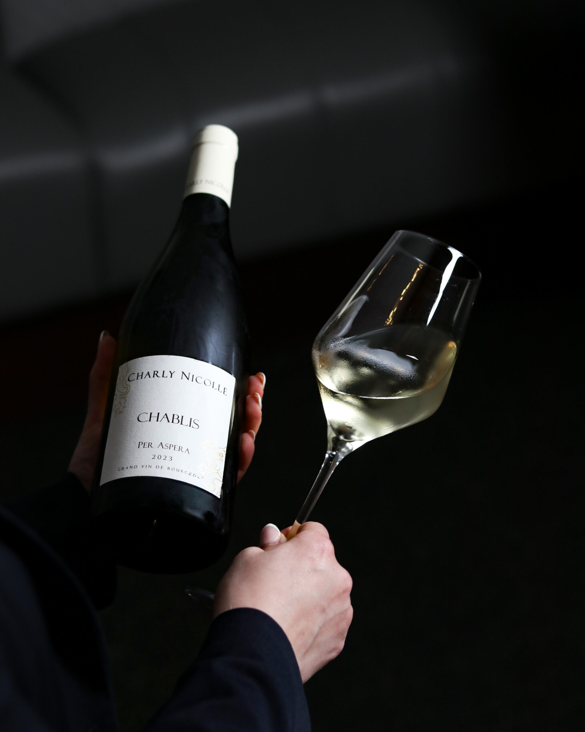 Wine bottle and glass held by server in The Cove