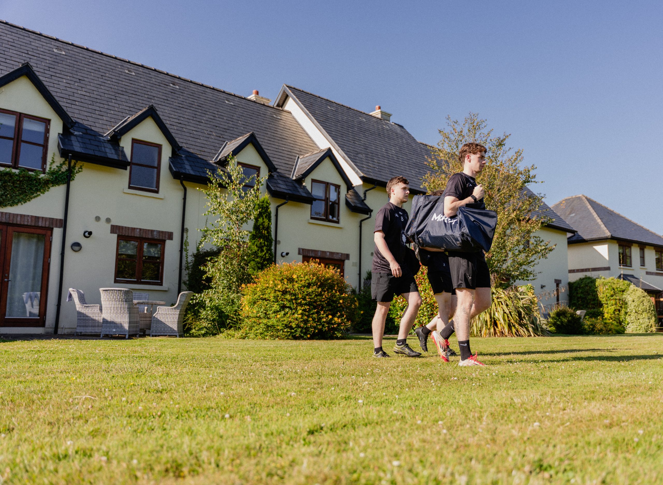 Football players walking from the back of the lodges towards the pitches
