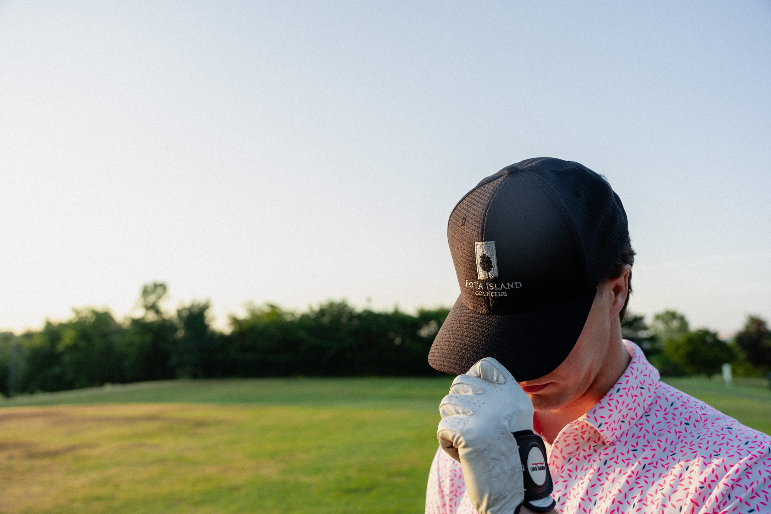 Golfer adjusting cap with Fota Island Resort logo