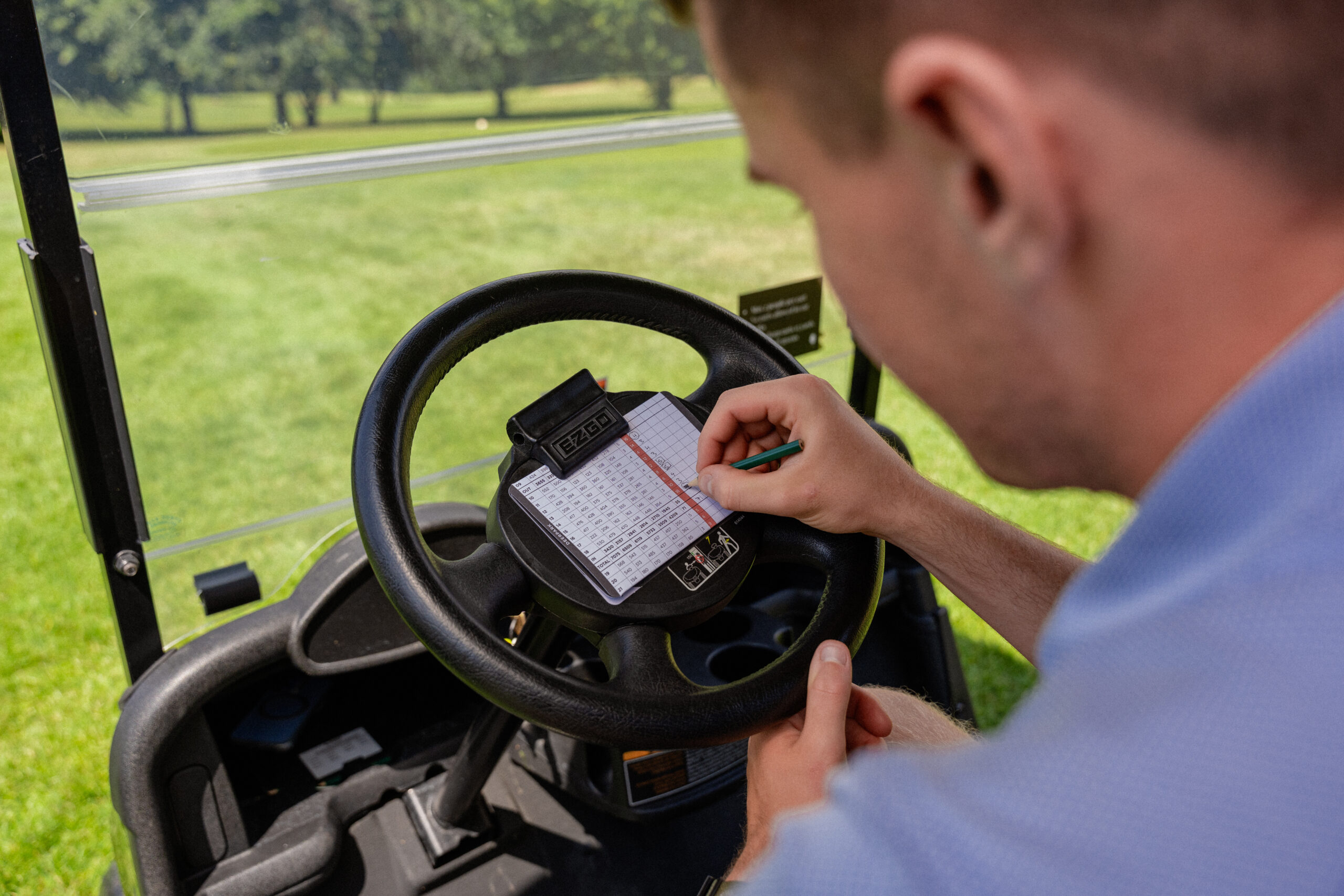 Golfer marking scorecard in golf buggy at Fota Island Resort