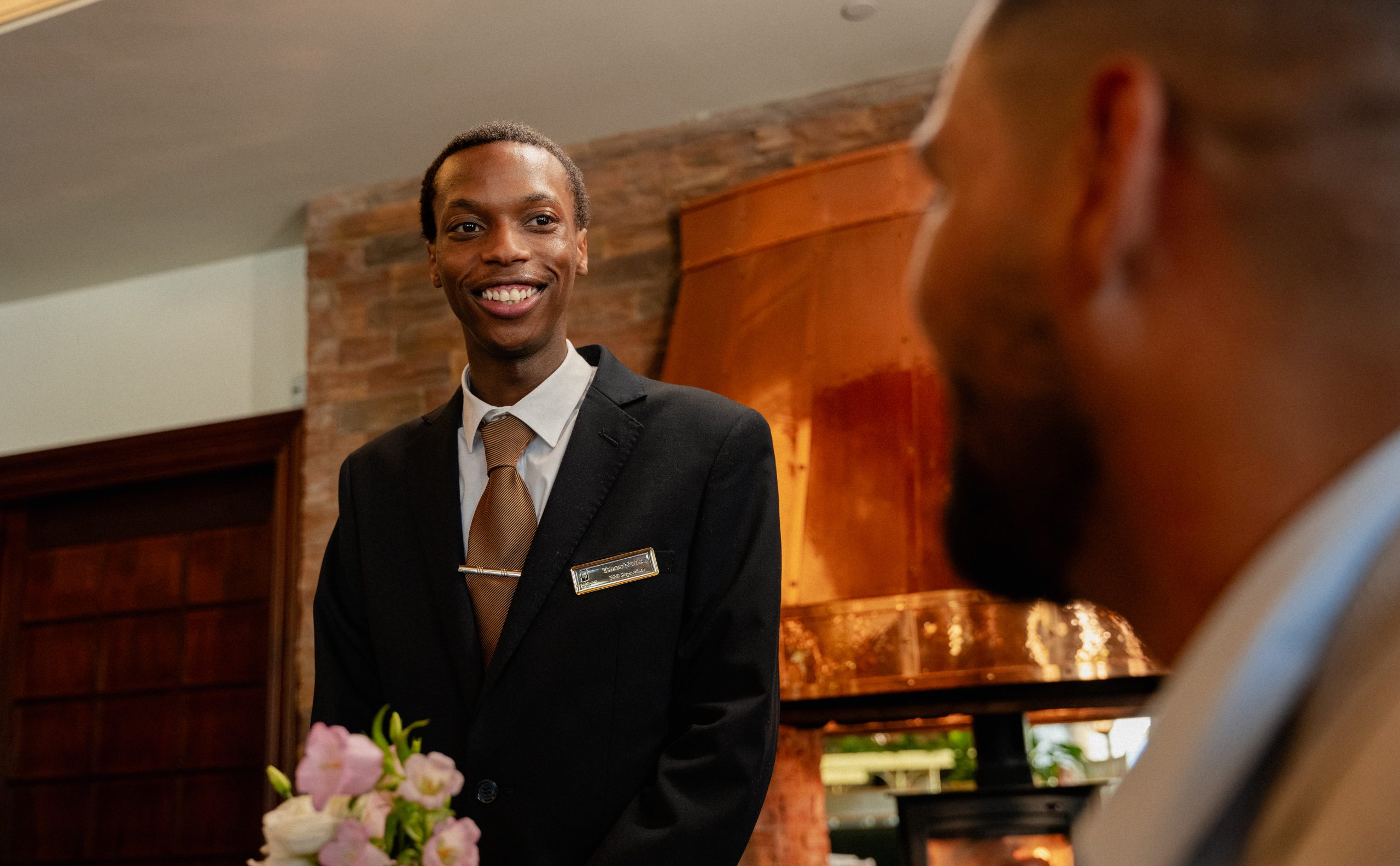 Waiter smiling with guest as they are about to order in The Amber Bar & Lounge