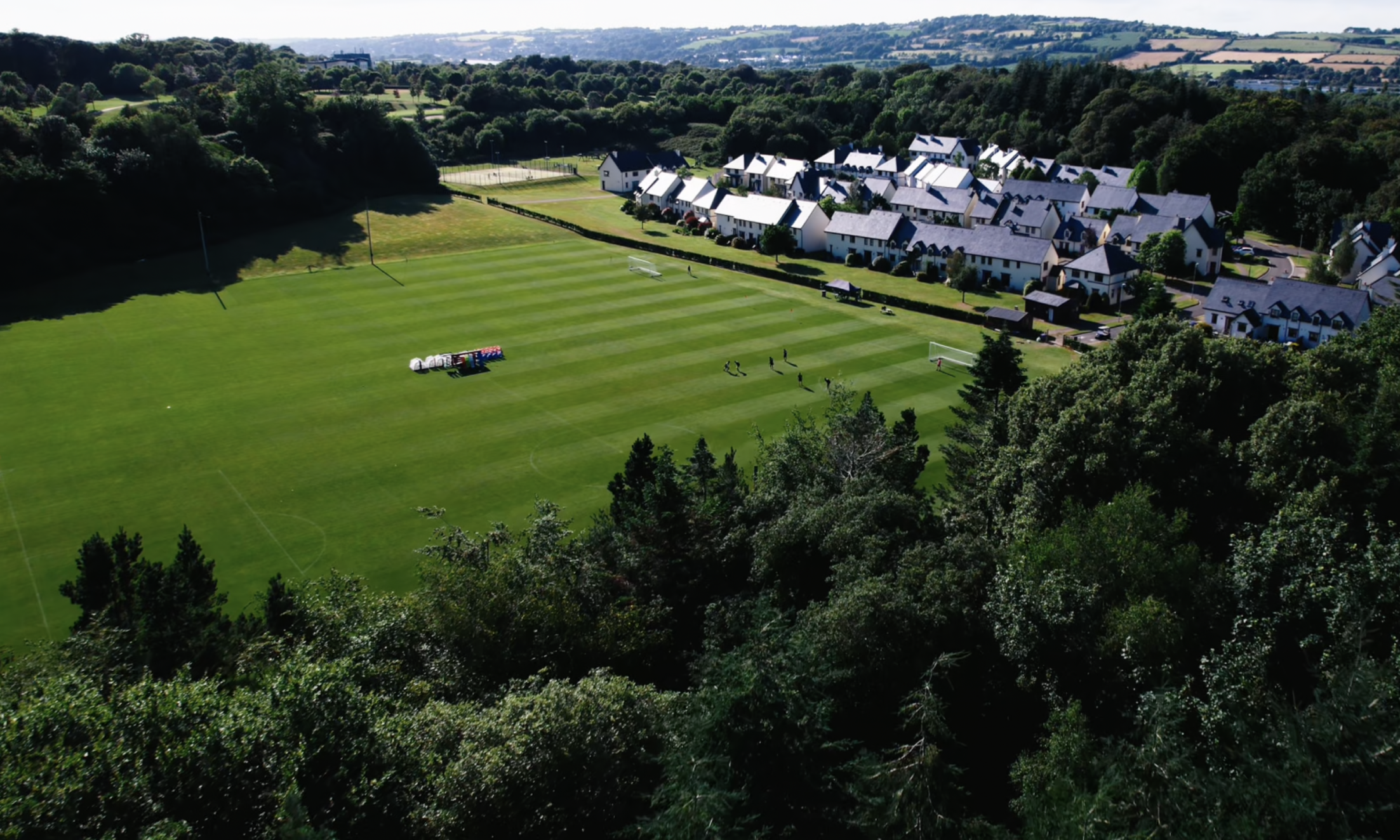 Drone shot of pitches, lodges and hotel in on image.